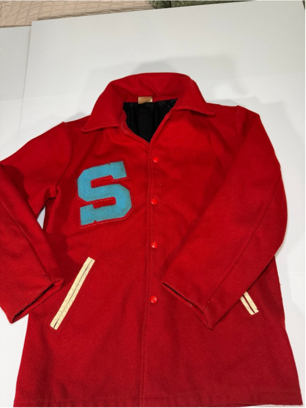 vintage red wool letterman jacket with a large blue "S" chenille patch and snaps